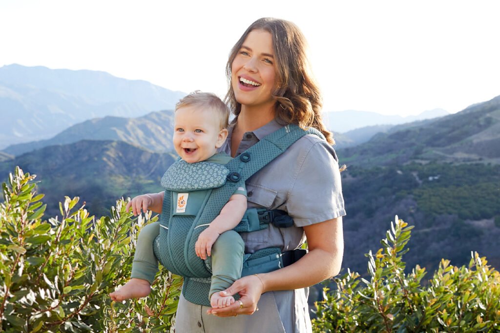 madre en el campo con bebe en mochila