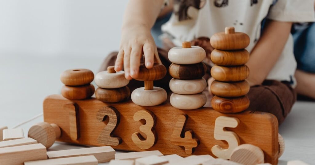 Child's hand interacting with wooden educational toys and number blocks indoors.